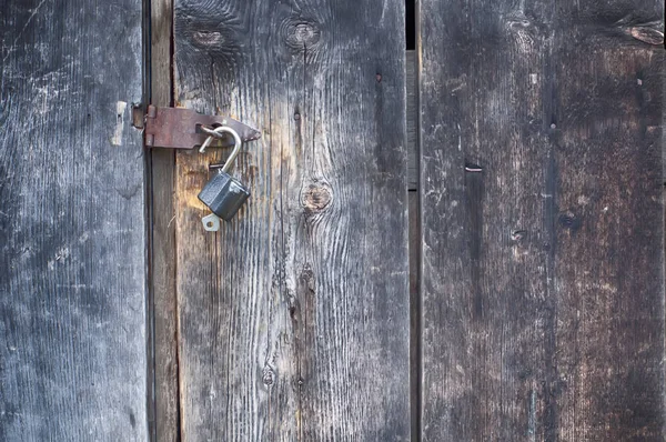 old padlock with keys on old wooden door