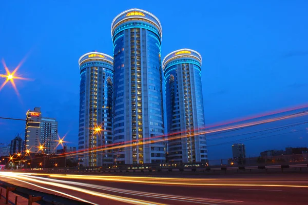 modern gökdelenler ve akşam araba hareketinden karayolu üzerinde farlar izleri