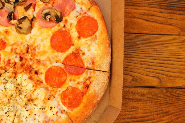 テーブルの上の箱にキノコとソーセージが入った新鮮なピザ — ストック写真