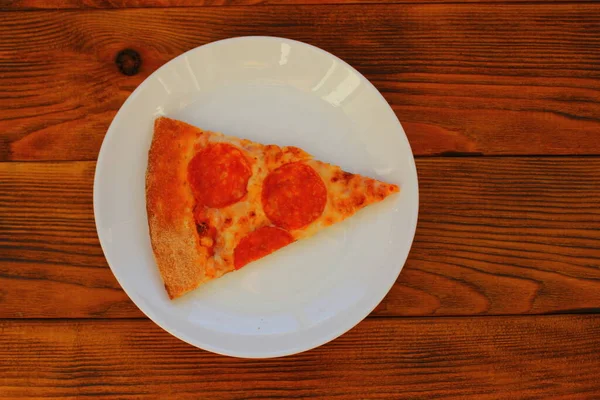 桌上白盘上的一片披萨 — 图库照片