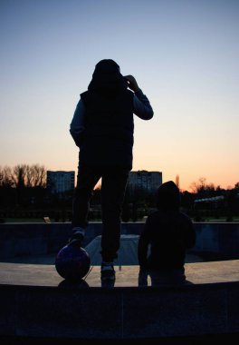 gün batımında taş ayakta iki arkadaş silüeti