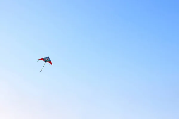 The wind kite flies against the blue sky background — Stock Photo, Image