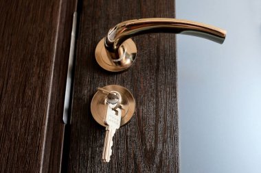 Sarı metal krom kapı kolu ve tuşları ile kilit. Kilitli iç kapılar. Krom kulplar ve anahtarlar otel odasına girer. 