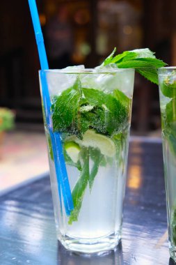 Nane ve limonlu mojito şeffaf bardakta pipetle. Lezzetli yaz ferahlatıcı içecekler, ev yapımı meşrubat. Alkolsüz naneli içecekler.