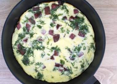 Yumurta, sosis ve yeşillik lezzetli hızlı kahvaltı. Bir tava üst görünümünde sosis ile Omlet.
