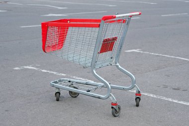 Alışveriş merkezinin yakınına park edilmiş boş bir alışveriş sepeti. Asfaltta boş metal sepet. Süpermarketler için alışveriş arabaları.
