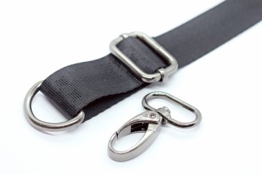 Çanta ve sırt çantaları yapmak için dikiş metal parçaları. Karabina, beyaz arka plan üzerinde koyu nikel renkte yarım halka ve uzunluk ayarlayıcısı. Çanta farklı yapmak için siyah bant.