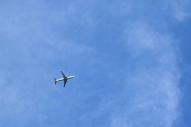 Uçak gökyüzünde yükseklerde uçar. Mavi, berrak gökyüzü. Alt görünüm.