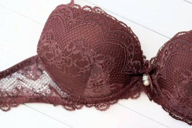 Dantelli kahverengi sutyen. Beyaz arka planda iç çamaşırı. Yakın plan destekli dantelli sutyen..