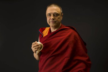 Keşiş elinde bir ayin mermisi tutuyor.