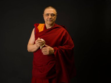 Keşiş elinde bir ayin mermisi tutuyor.