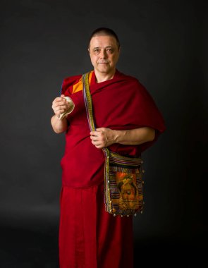 Keşiş elinde bir ayin mermisi tutuyor.