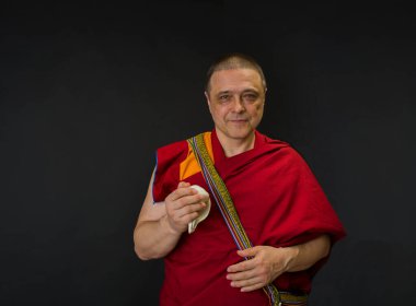 Keşiş elinde bir ayin mermisi tutuyor.