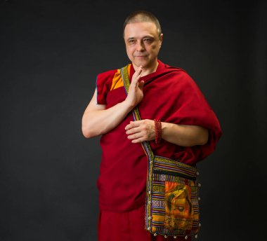 Kırmızı kesa cüppeli bir Budist keşişin portresi.