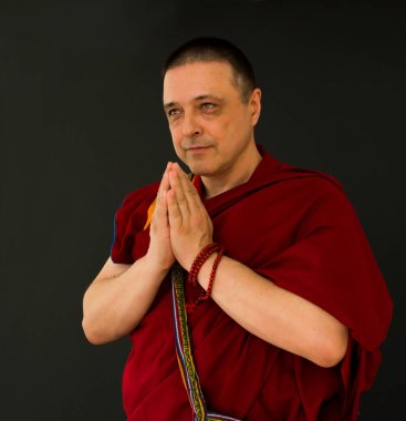 Kırmızı kesa cüppeli bir Budist keşişin portresi.