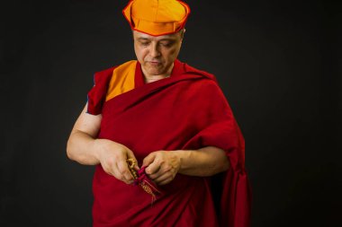 Kırmızı kesa cüppeli bir Budist keşişin portresi.