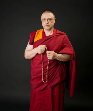 Kırmızı kesa cüppeli bir Budist keşişin portresi.