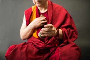 Keşiş ayin çanı ve vajra tutuyor.