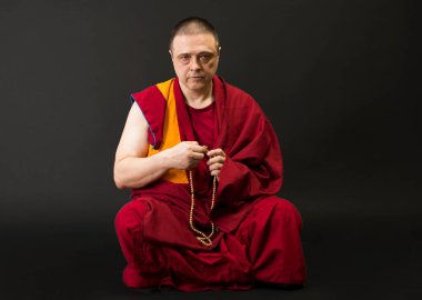 Keşiş tespihi elinde tutuyor.