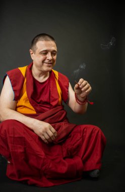 Budist keşiş elinde tütsü çubuğu tutuyor.
