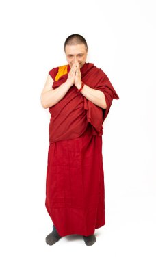 Beyaz arka planda kırmızı giysili bir Tibetli keşişin hademesi.