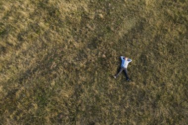 Adam çimlerin üzerinde dinleniyor. Üst Görünüm