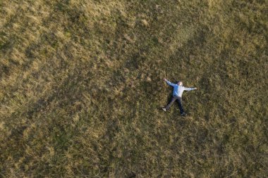 Adam çimlerin üzerinde dinleniyor. Üst Görünüm
