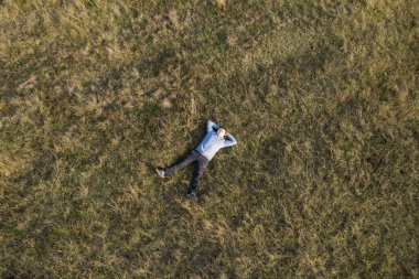 Adam çimlerin üzerinde dinleniyor. Üst Görünüm