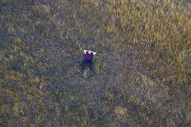 Adam çimlerin üzerinde dinleniyor. Üst Görünüm