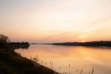 Büyük bir nehrin kıyısında güzel bir gün batımı