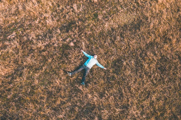 Guy is resting on the grass. View top