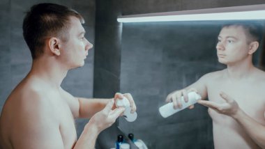 Adam yüzüne tıraş jeli sürüyor.