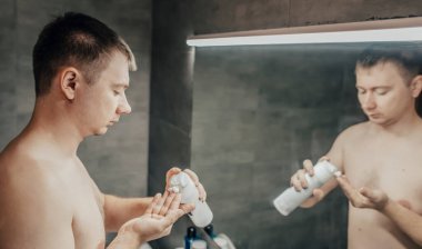 Adam yüzüne tıraş jeli sürüyor.