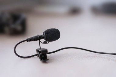 Lavalier mikrofon takmak için bir mandalla birlikte masanın üzerinde duruyor. yakın plan