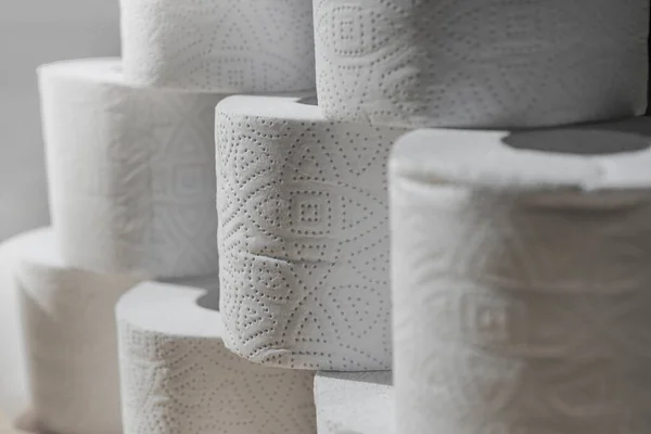 Rolls of toilet white paper stand on top of each other.