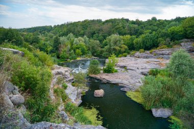 Nehir, büyük taşlar ve kayalarla dolu bir kanyondan akar.