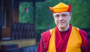 Kırmızı elbiseli ve şapkalı bir keşişin portresi.