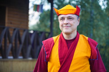 Kırmızı elbiseli ve şapkalı bir keşişin portresi.