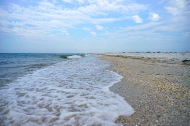 Deniz dalgaları ve temiz su kıyıya vuruyor.