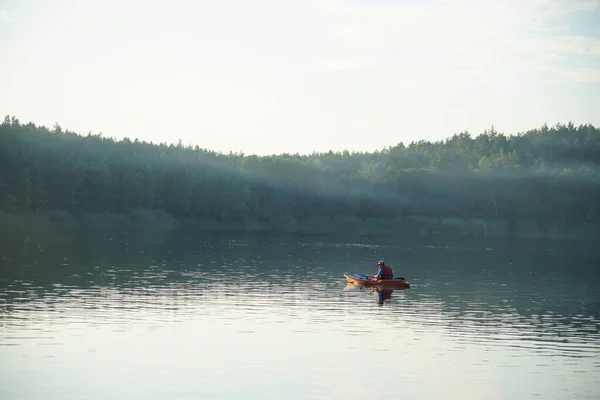男は霧の中の湖のカヌーに乗って — ストック写真