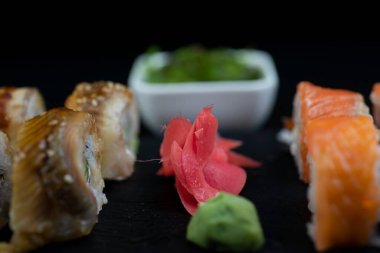 Turşu turşusu sushi ile yakın plan arasında uzanır.