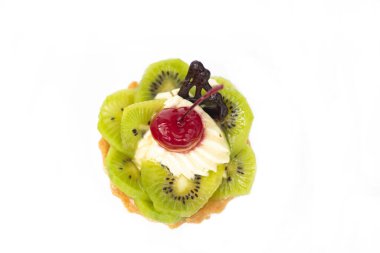 Kivili ve kremalı pasta, turuncu dilimlerin yanında. Beyaz arkaplan,