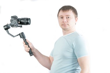 Adam elinde kamerayla 3 eksenli dengeleyici tutuyor ve selfie çekiyor..