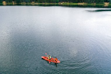 Kano nehir manzarasında yüzüyor, İHA 'nın üst görüntüsü, kanoda iki adam.