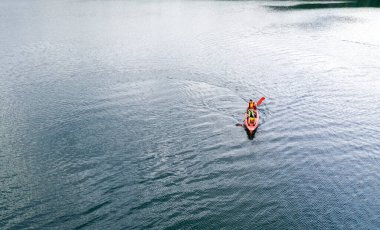 Kano nehir manzarasında yüzüyor, İHA 'nın üst görüntüsü, kanoda iki adam.