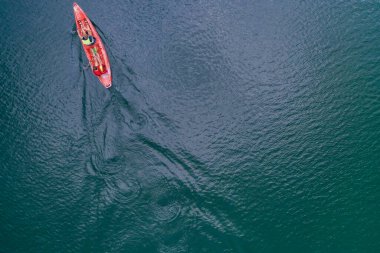 Kano nehir manzarasında yüzüyor, İHA 'nın üst görüntüsü, kanoda iki adam.