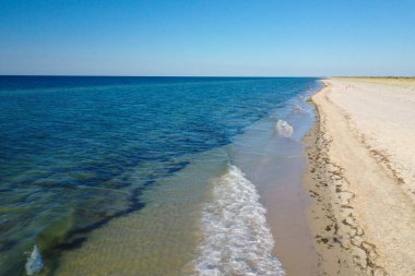 Adanın kıyısındaki dalgalardan gelen mavi su ve beyaz köpük. en üstteki görünüm