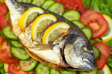 Sebzeli ızgara dorado balığı: salata, domates, salatalık, yeşil biber ve limon.