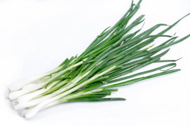 Beyaz arka planda yeşil tüylü taze soğanlar.