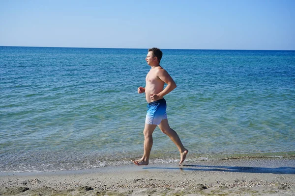 Adam sabahları deniz kıyısında masmavi suyla koşuyor..